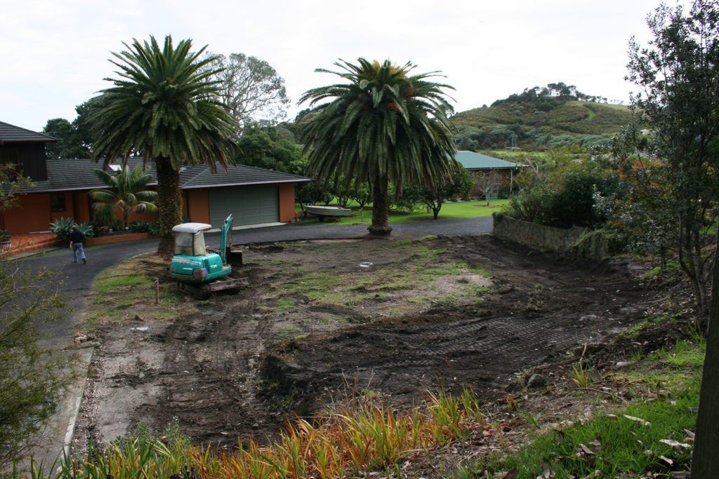 bare site before implementing new subtropical garden design with waterfall and large rocks